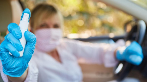 Frau in medizinischer Kleidung hält Desinfektionsmittel in der Hand